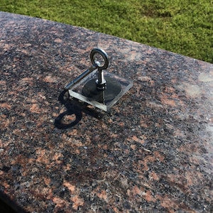 Metal headstone flower saddle clip with side hooks on granite marker