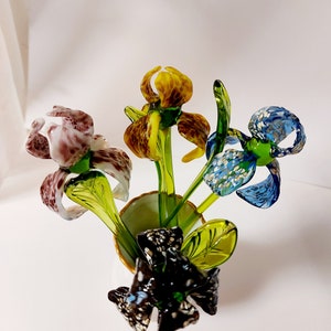 Colorful glass iris flower figurine with green stems, yellow buds, blue petals, black base
