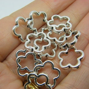 Antique silver-tone flower bead frames, small metal bead caps in hand
