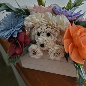 Dog flower bouquet with a cream plush dog at center among colorful blooms