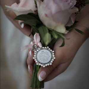 Round rhinestone keepsake charm pendant on ribbon, held in an open hand