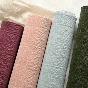 Crepe paper rolls in burgundy, blush pink, light blue, and dark green