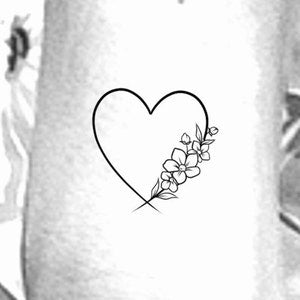 Temporary tattoo of a heart outline with small wildflower bouquet design