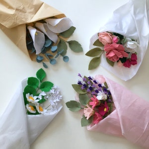 Assorted wrapped felt flower bouquets with pink, blue, purple, and green blooms