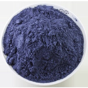 Blue butterfly pea tea powder in a white bowl