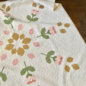 White quilt top with multicolor floral and star patchwork blocks