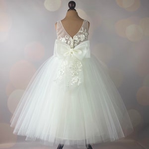 Ivory flower girl dress with lace bodice, tulle skirt, and satin bow straps
