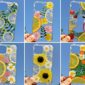 Clear bumper phone case with pressed flowers and dried fruit, including lemon and daisies