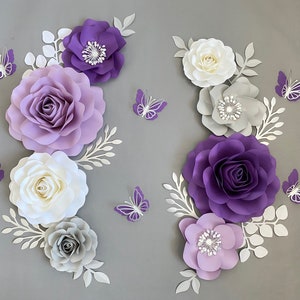 Purple and white paper flower wall decor set with butterflies and leafy accents