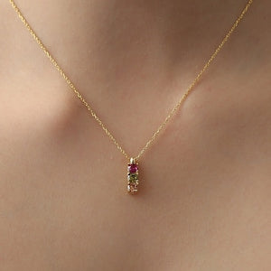 Gold-tone birthstone pendant necklace with a small multicolor charm