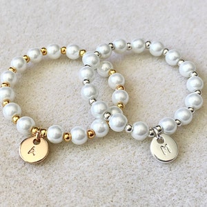 Pearl beaded bracelet with small engraved heart charms and gold-tone accent beads