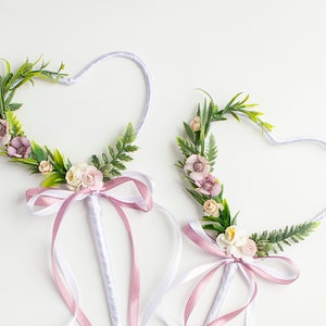 Pink flower girl wand with blush flower, ribbon bow, and green leaf accents