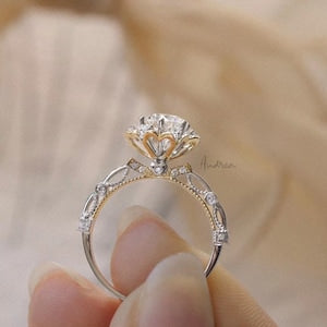 Two-tone flower solitaire ring with prong-set round center stone and halo of small gems