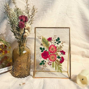 Botanical pressed flower frame with colorful rose and green leaves in a light wood border