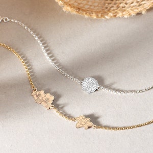 Adjustable charm bracelet with small floral and leaf pendants on a thin chain