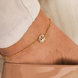 Gold lotus flower charm anklet on ankle, delicate chain with small pendant