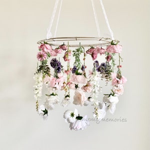Floral and butterfly nursery mobile with pink and white hanging decorations, round frame