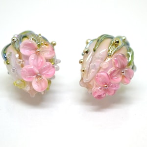 Pair of pink flower lampwork beads with green leaves and gold-tone bead caps