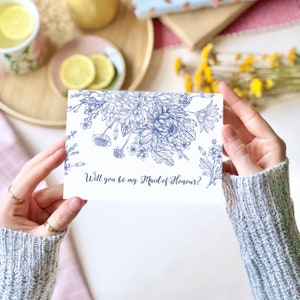 Maid of Honour proposal card with blue floral border and handwritten message on white