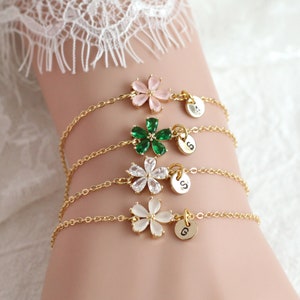 Gold-tone toddler bracelet with flower charms, green heart pendant, and letter bead