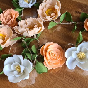 Felt flower garland with peach and white blooms and green leaf cutouts