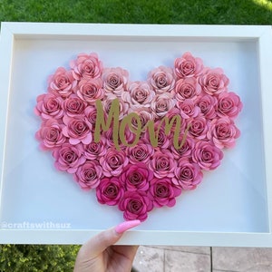 Heart-shaped flower box with pink paper roses and “Mom” lettering inside a white frame