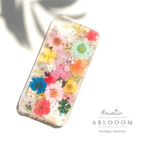 Clear phone case with pressed flowers and cat stickers, colorful floral collage