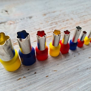 Set of flower-shaped metal cutters with colored handles, assorted sizes