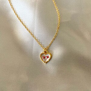 Gold heart resin necklace pendant with small pressed flower details on chain