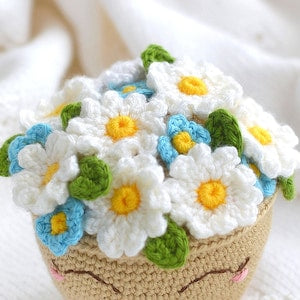 Crochet flower basket with white daisies, blue forget-me-nots, and yellow centers