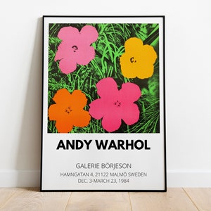 Framed Andy Warhol flower exhibition poster with bright pink, yellow, and orange blooms