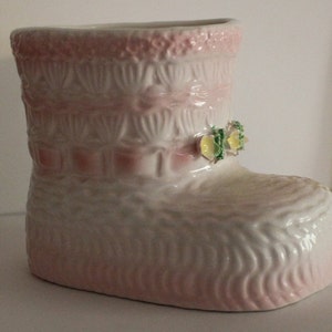 Pink and white textured baby bootie planter with shamrock charm