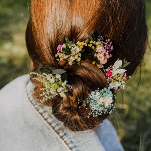 Natural dried flower hairpins with small wildflower clusters on dark hair