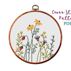 Floral counted cross-stitch pattern in wooden hoop frame, wildflowers and stems