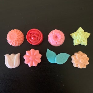 Assorted flower-shaped scented wax melts in pink, red, yellow, teal, and cream