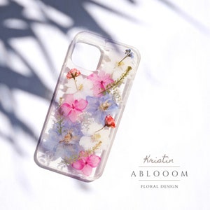 Handmade pressed-flower phone case, clear back with pink and blue floral pieces