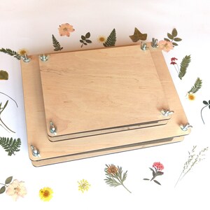 Wooden flower press with metal corner screws and clear top plate for pressing flowers