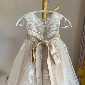 Flower girl dress with lace appliqué, tulle skirt, and satin sash