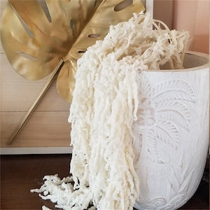 Bleached white hanging amaranthus dried flowers, feathery strands draping from basket