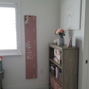 Floral height chart with vertical ruler markings and flower accents for kids room