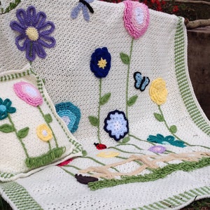 Crocheted floral afghan blanket with butterflies, flowers, and green border