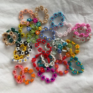 Beaded flower rings set with multicolor floral designs and adjustable bands
