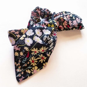 Floral adjustable bow hairband on dark fabric with colorful flower print