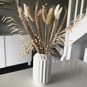 Dried flower arrangement in white striped vase with natural pampas stems