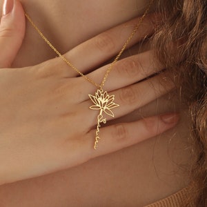 14k gold birth flower necklace with small floral pendant and dangling charm