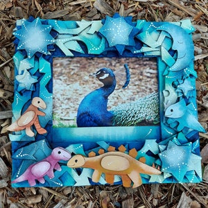 Blue dinosaur photo frame with T-rex artwork and star cutouts
