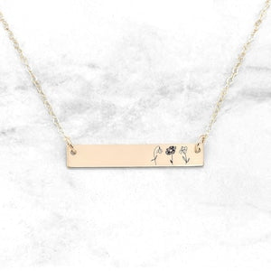 Gold-tone birth month flower bar necklace with small engraved flower icons on bar
