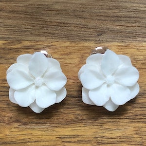White resin flower clip-on earrings with scalloped petals, one pair