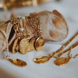 Gold-tone floral birth flower necklace with flower pendants and small pearl accents
