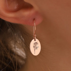 Rose gold floral dangle earrings with oval charm and small signature flower design